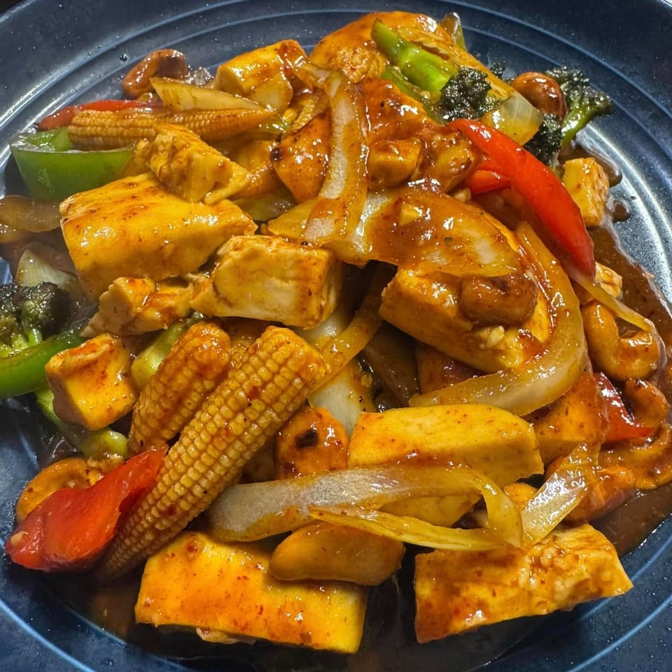 Close-up of Maya Thai Eatery's stir-fried tofu with baby corn, bell peppers, and onions.